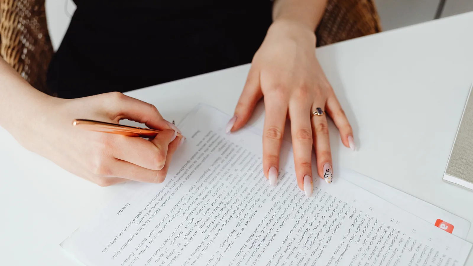 A person reviewing a non-compete agreement with a pen before signing