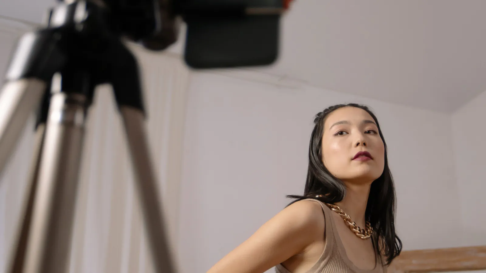 A content creator filming a sponsored video on a smartphone mounted to a tripod, illustrating influencer marketing and FTC disclosure requirements for businesses