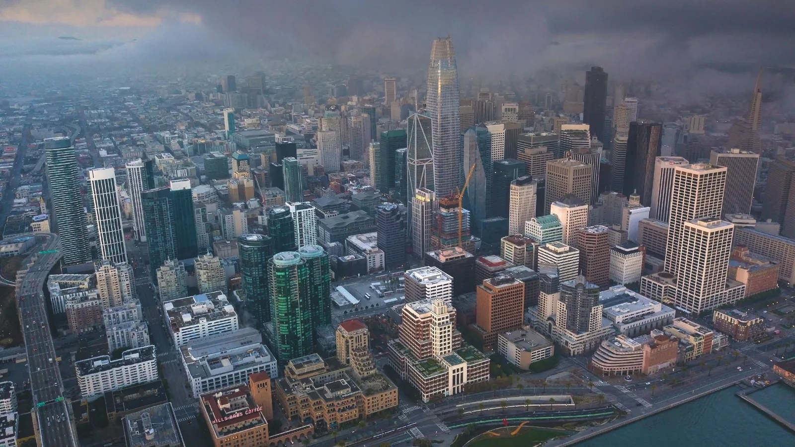 Aerial view of the San Francisco financial district skyline at dusk, with Salesforce Tower rising above downtown