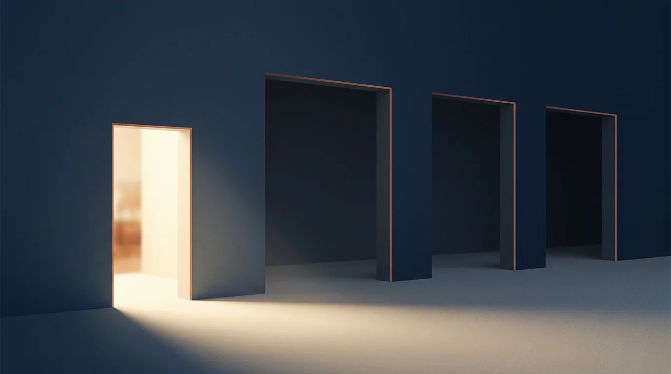 A narrow brightly lit doorway in a long wall, beside three much wider openings standing unlit in shadow, all on the same continuous floor